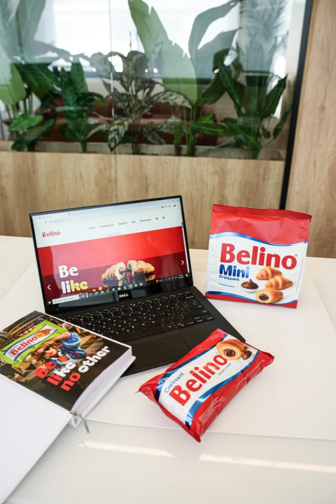 Laptop and Belino croissant packs on a desk at the Interelka offices
