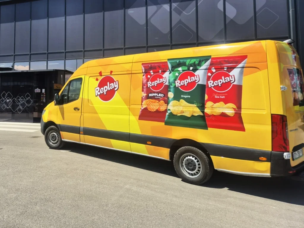 Replay-branded delivery van parked outside a commercial building